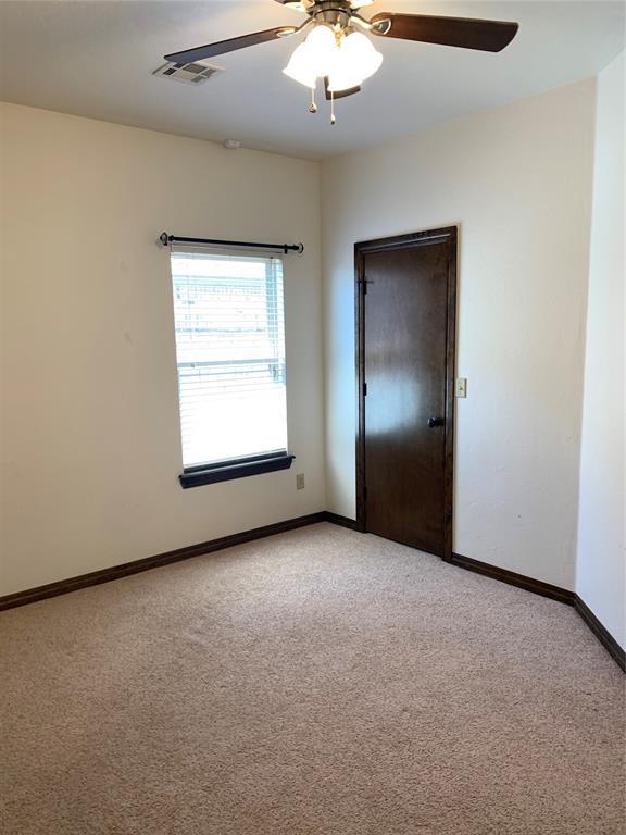 unfurnished room with ceiling fan and light carpet