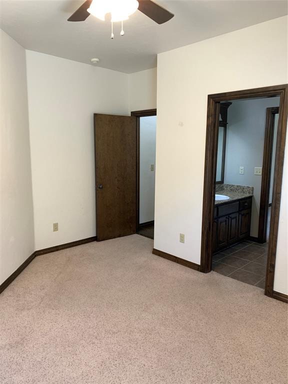 unfurnished bedroom featuring ensuite bath, ceiling fan, and light carpet