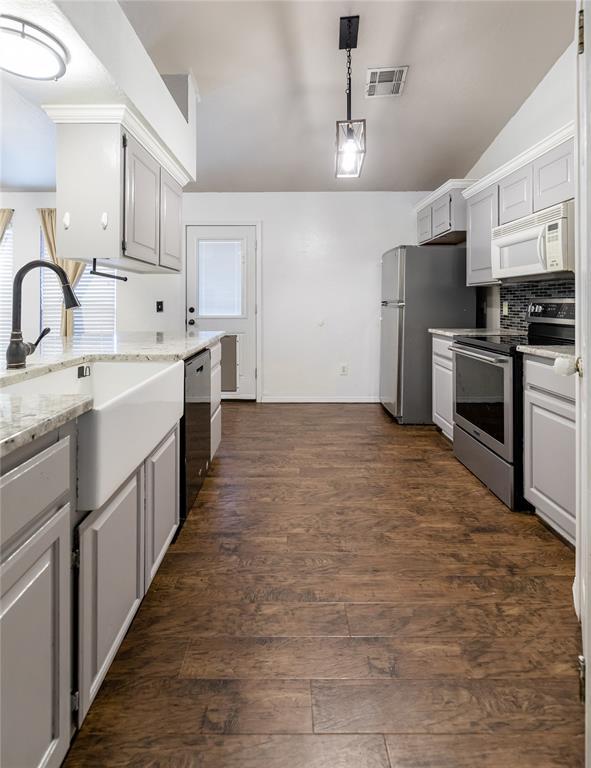 kitchen featuring appliances with stainless steel finishes, dark hardwood / wood-style floors, sink, and white cabinets