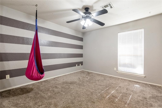 unfurnished room featuring ceiling fan and carpet flooring