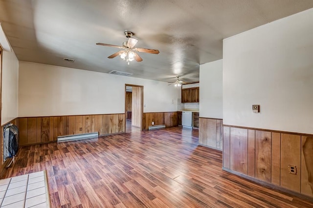 unfurnished room with ceiling fan, baseboard heating, and dark hardwood / wood-style flooring