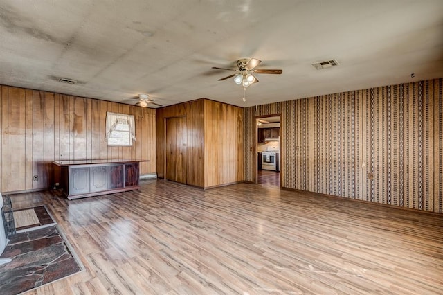 unfurnished living room with ceiling fan and hardwood / wood-style floors