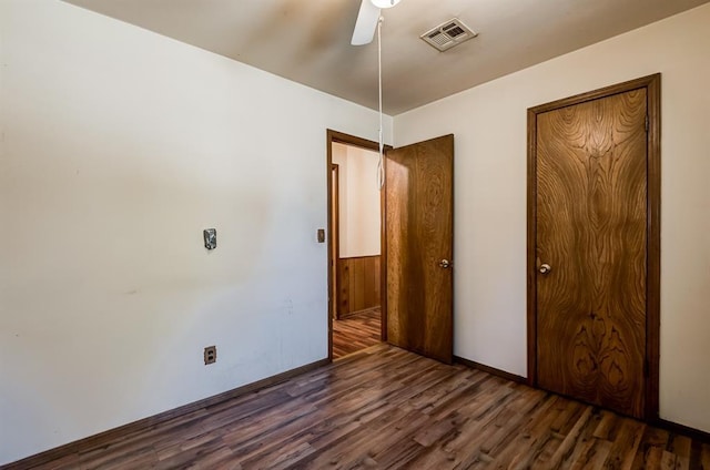 unfurnished bedroom with ceiling fan and dark hardwood / wood-style flooring