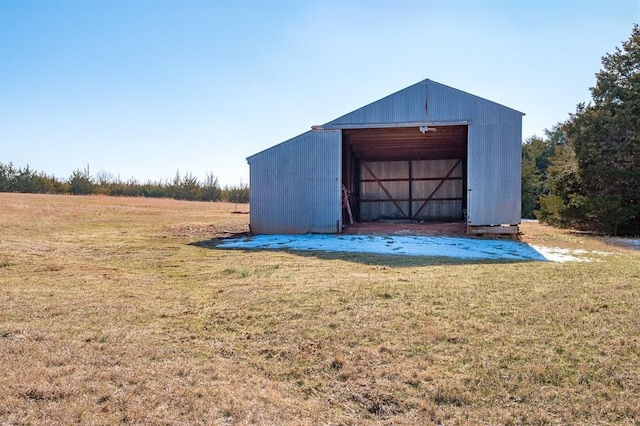 view of outdoor structure featuring a lawn and a rural view