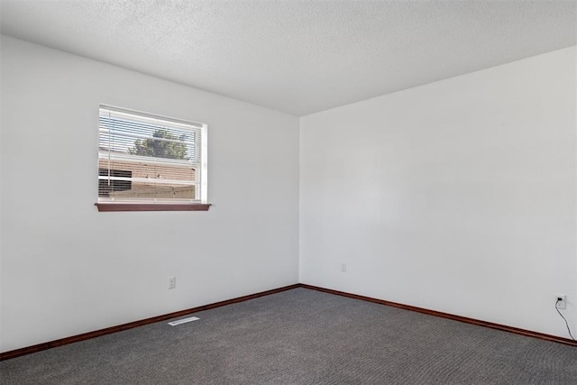 carpeted spare room featuring a textured ceiling