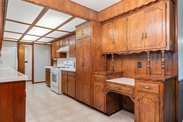 kitchen featuring sink, white appliances, and tile counters