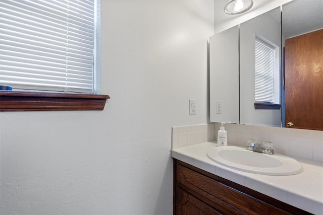 bathroom with vanity and tasteful backsplash