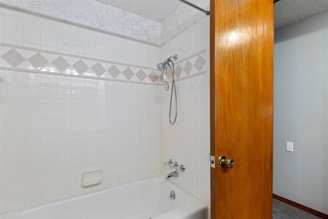 bathroom featuring tiled shower / bath combo and a textured ceiling