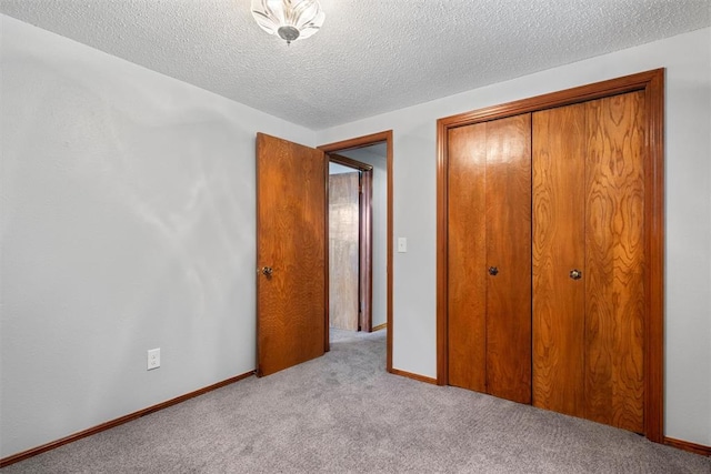 unfurnished bedroom featuring a closet, light colored carpet, and a textured ceiling