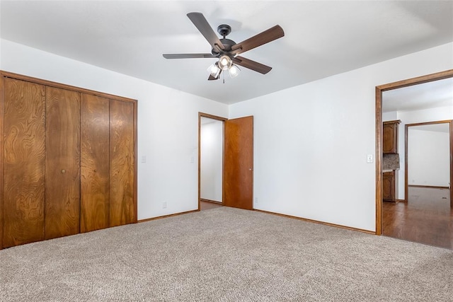 unfurnished bedroom with ceiling fan, a closet, and carpet