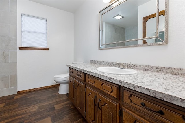 bathroom featuring toilet, hardwood / wood-style flooring, and vanity