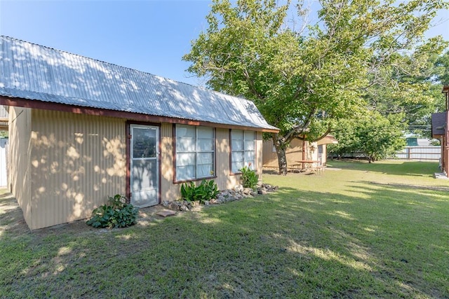 rear view of property with a yard and an outdoor structure