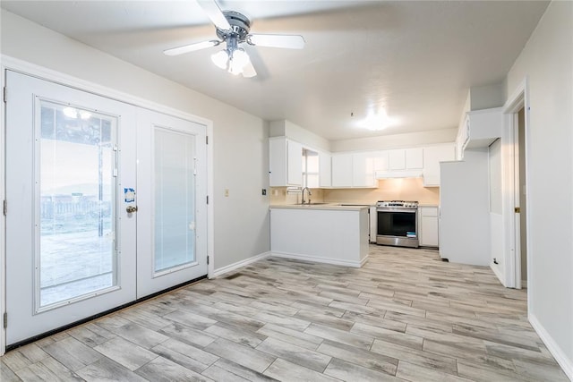 kitchen with ceiling fan, stainless steel stove, sink, white cabinets, and french doors
