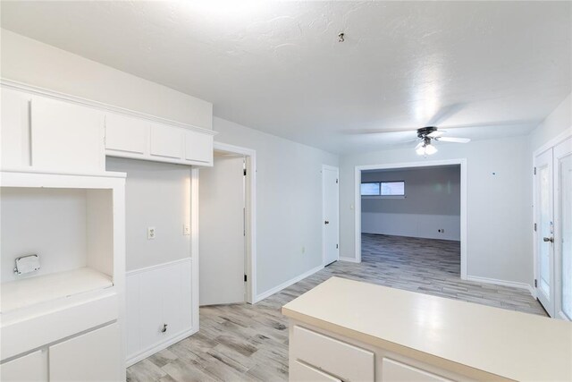kitchen with ceiling fan, white cabinets, and light wood-type flooring