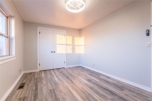 unfurnished bedroom featuring hardwood / wood-style flooring and a closet