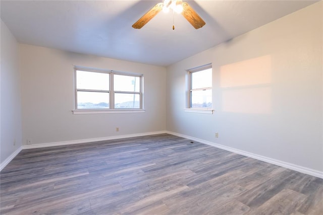 empty room featuring ceiling fan and dark hardwood / wood-style flooring