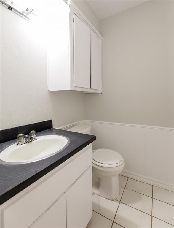 bathroom featuring toilet, vanity, and tile patterned flooring