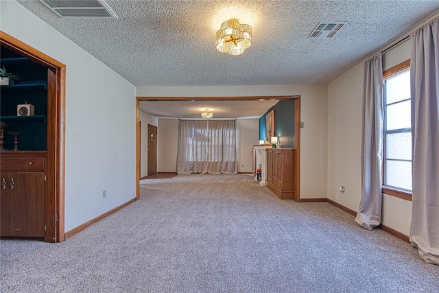 carpeted empty room with a textured ceiling