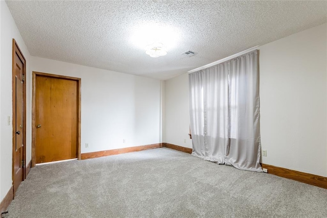 carpeted spare room with a textured ceiling