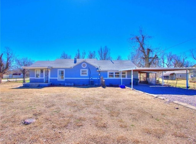 ranch-style house featuring a front yard and a carport