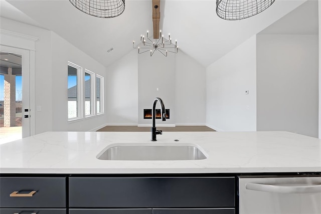 kitchen featuring sink, light stone counters, lofted ceiling with beams, a center island with sink, and dishwasher