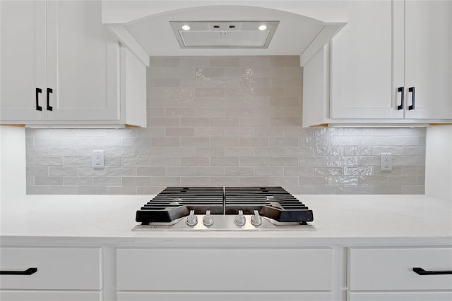 kitchen featuring light stone counters, white cabinetry, decorative backsplash, and premium range hood