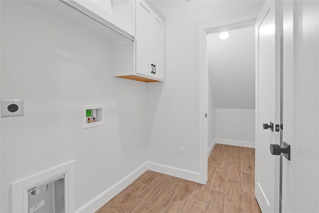 clothes washing area with cabinets, electric dryer hookup, washer hookup, and light wood-type flooring