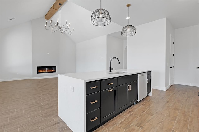 kitchen featuring a kitchen island with sink, sink, stainless steel dishwasher, and hanging light fixtures