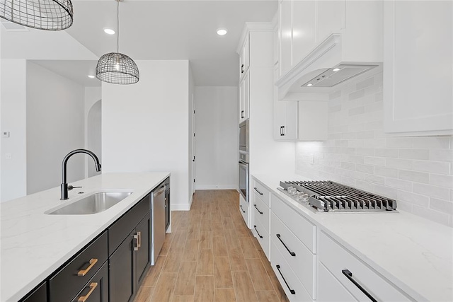 kitchen featuring white cabinetry, sink, decorative backsplash, and decorative light fixtures