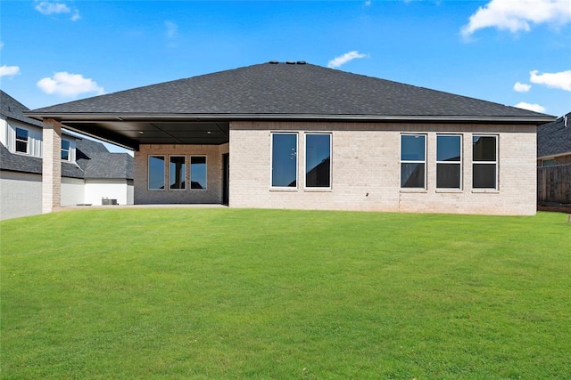 rear view of property with a lawn