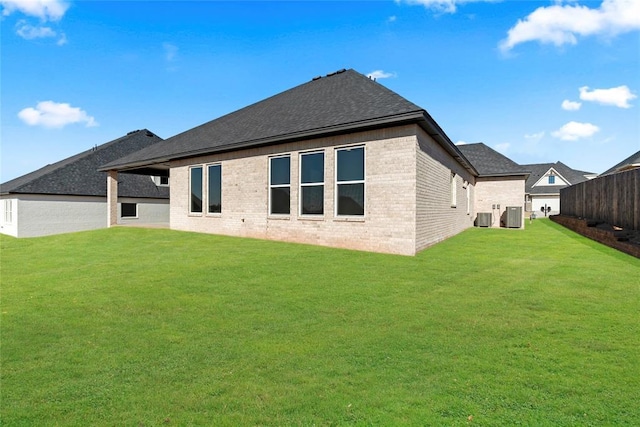 back of property with a yard and central air condition unit