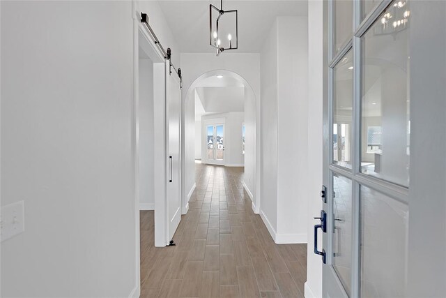 hall with light hardwood / wood-style floors and a barn door