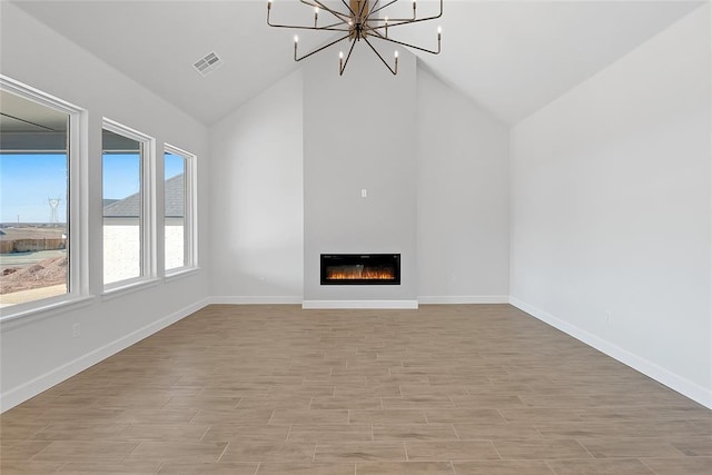 unfurnished living room with an inviting chandelier, high vaulted ceiling, and light wood-type flooring