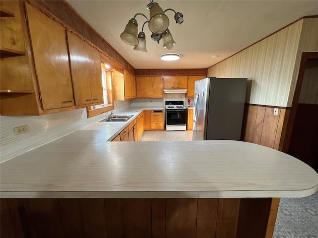 kitchen with wooden walls, stainless steel refrigerator, range, and kitchen peninsula