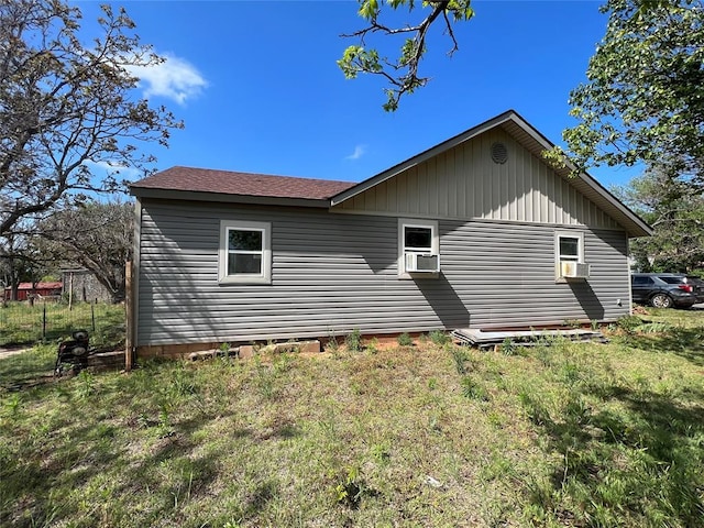 view of side of home with cooling unit and a yard