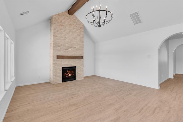 unfurnished living room with light hardwood / wood-style flooring, vaulted ceiling with beams, a notable chandelier, and a fireplace