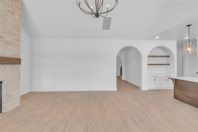 unfurnished living room featuring a brick fireplace and light wood-type flooring