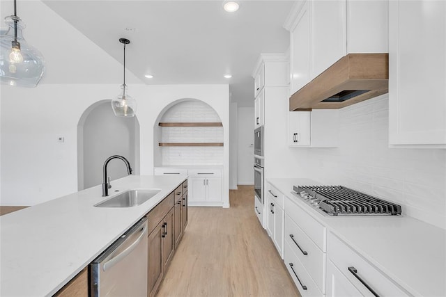 kitchen featuring white cabinetry, appliances with stainless steel finishes, sink, and decorative light fixtures