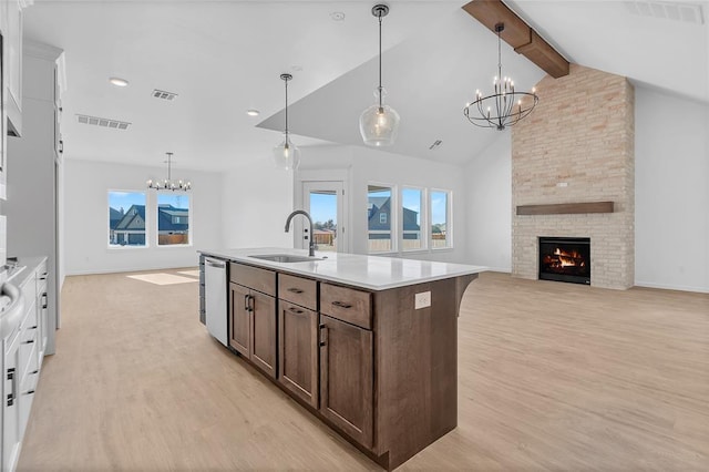 kitchen featuring pendant lighting, sink, dishwasher, and beamed ceiling