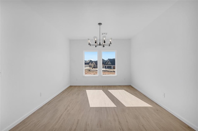 unfurnished dining area with a chandelier and light hardwood / wood-style flooring