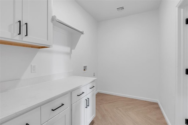 laundry room featuring cabinets, hookup for a washing machine, and light parquet floors