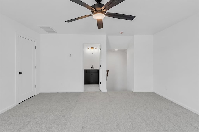 carpeted empty room featuring ceiling fan and sink