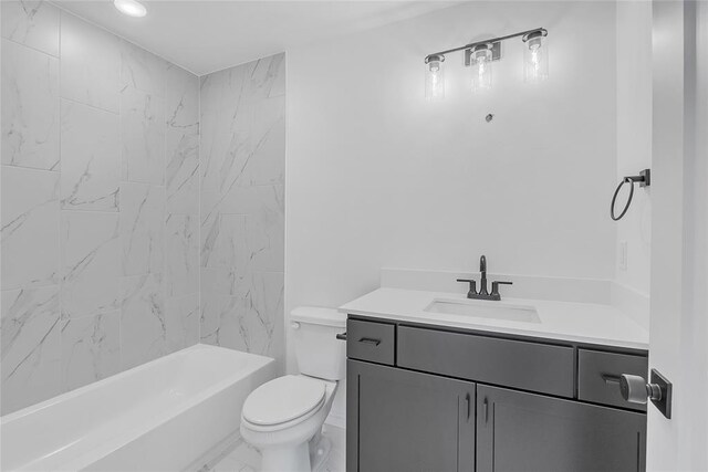 full bathroom featuring tiled shower / bath, vanity, and toilet