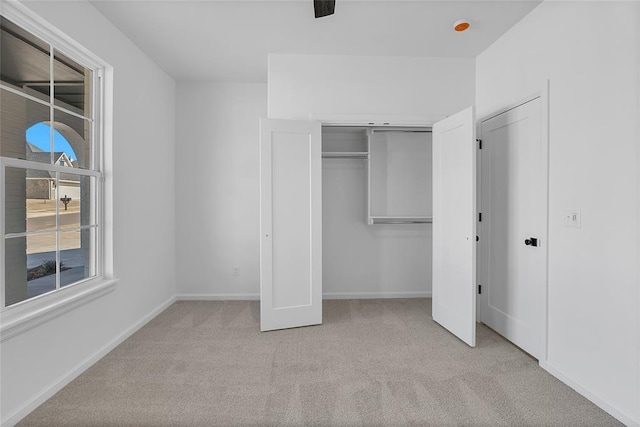 unfurnished bedroom featuring light carpet and ceiling fan