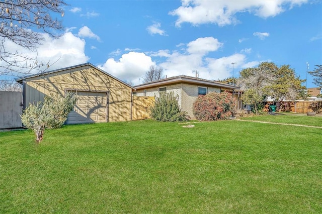 ranch-style house featuring a garage, a front lawn, and an outdoor structure