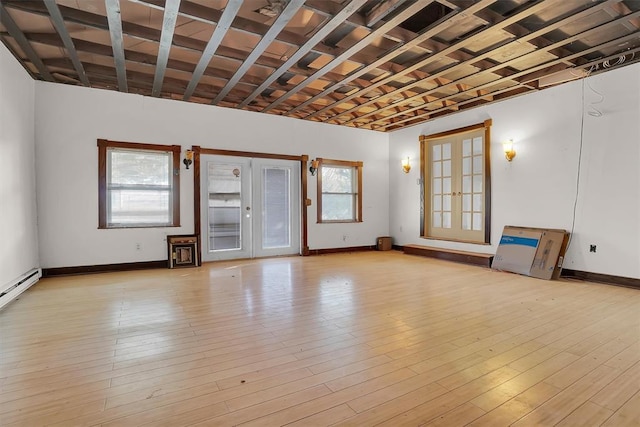 unfurnished living room with light wood-type flooring and french doors