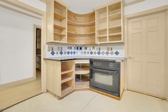 kitchen featuring black oven and tasteful backsplash