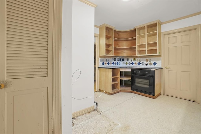 kitchen featuring crown molding, decorative backsplash, and black oven