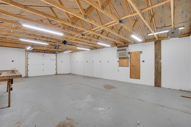 garage featuring a wall mounted AC and a garage door opener