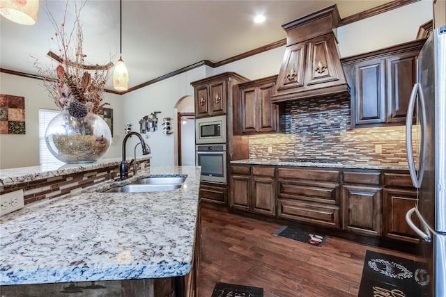 kitchen with appliances with stainless steel finishes, dark hardwood / wood-style floors, tasteful backsplash, pendant lighting, and sink